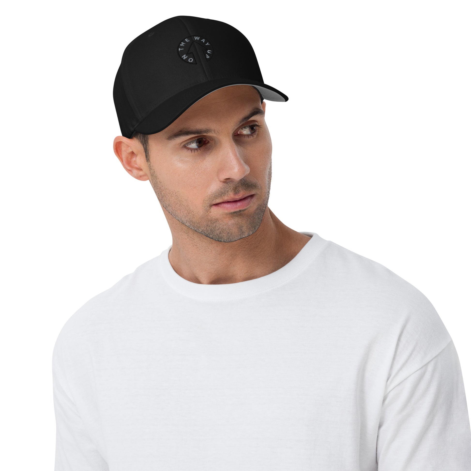 A young man wearing an On The Way Up Apparel Stretch Fit On The Way Up Signature Cap and a white t-shirt looks pensively to the side.