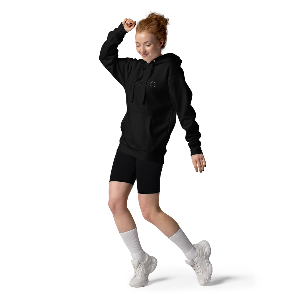 A woman with curly red hair wearing an On The Way Up Progress Hoodie, shorts, and white sneakers is captured mid-jump against a black background, epitomizing "On The Way Up" by On The Way Up Apparel.