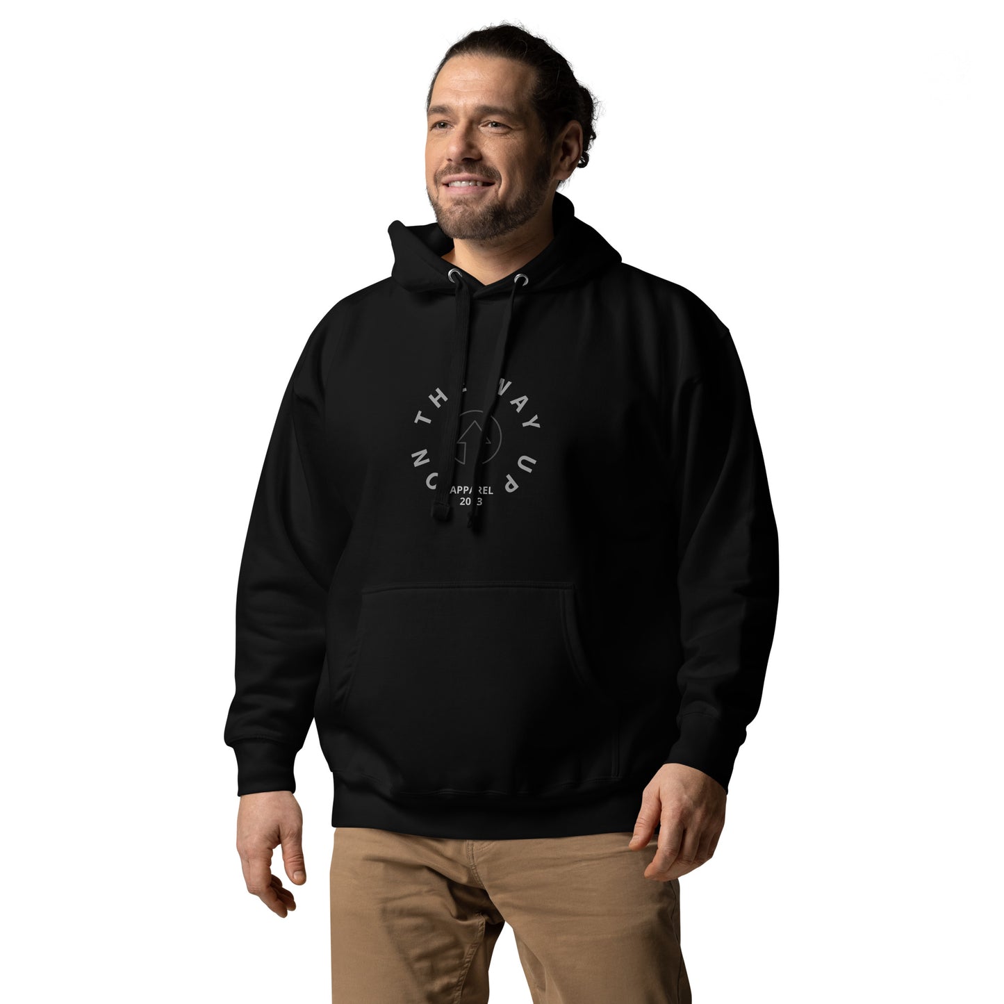 A man smiling, wearing a Vintage Style Hoodie with "Manchester Premium Quality" text design on the front from On The Way Up Apparel, paired with beige pants, standing against a white background.