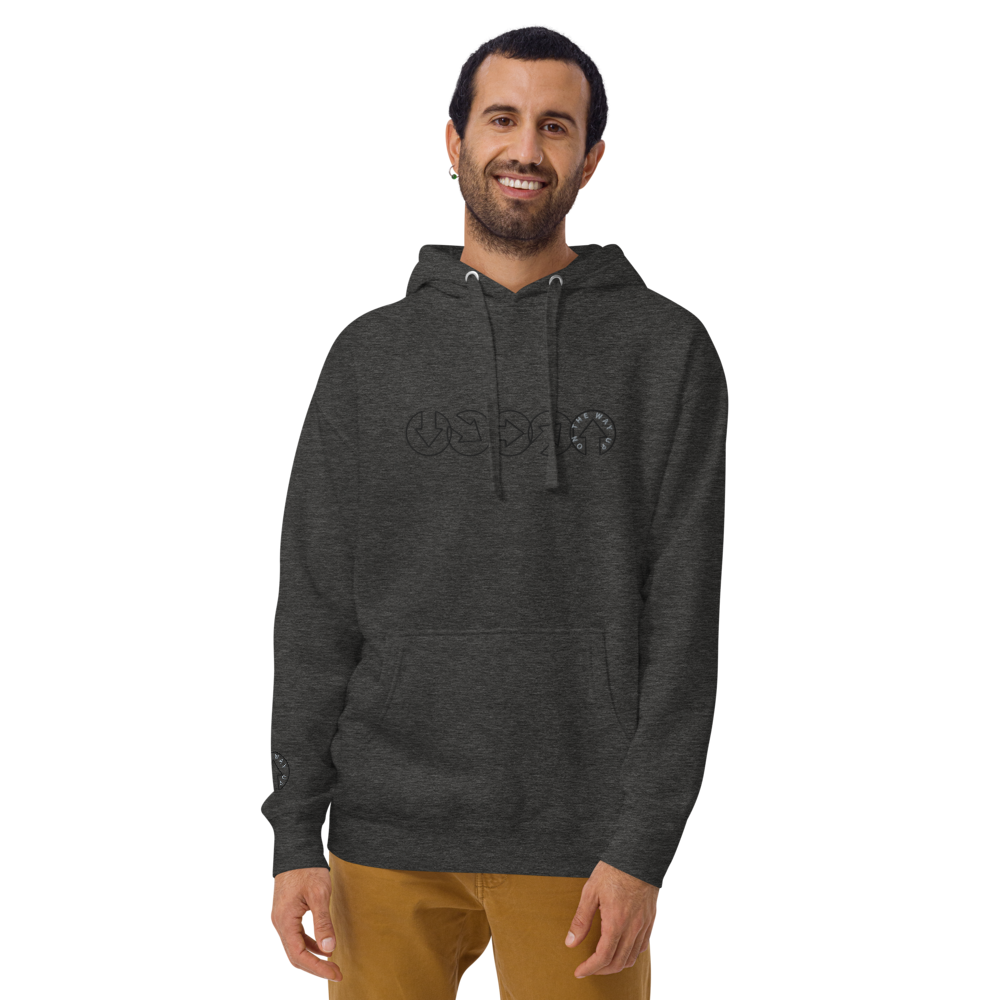 A smiling man in an On The Way Up Apparel gray hoodie with a "Premium Quality" cursive logo and khaki pants stands against a plain background. He has short dark hair and a well-groomed beard.