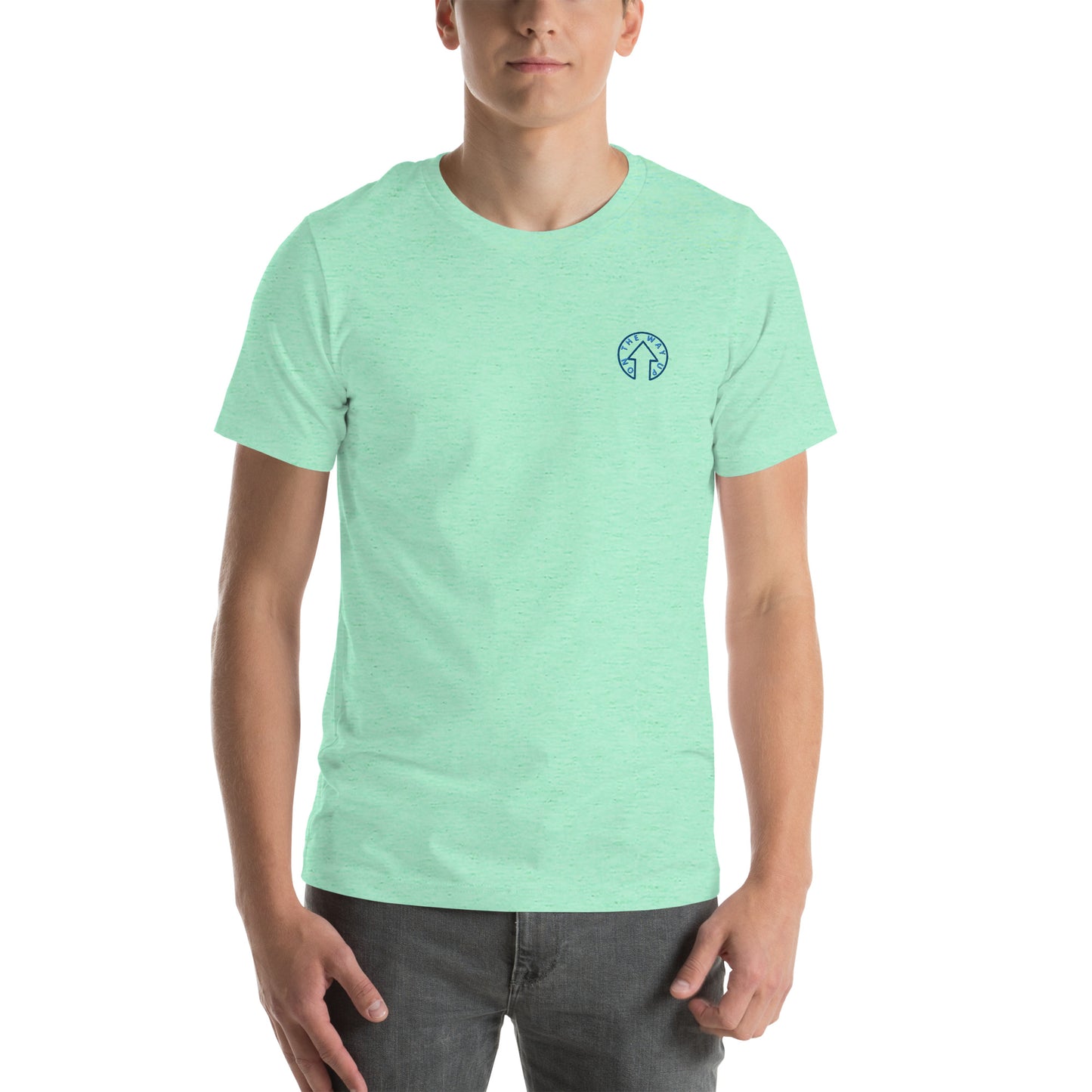 A young man stands wearing a On The Way Up Apparel BE BOLD - On The Way Up Embroidered Logo T-shirt in mint green with a small logo on the left chest and gray jeans, facing the camera on a plain white background.