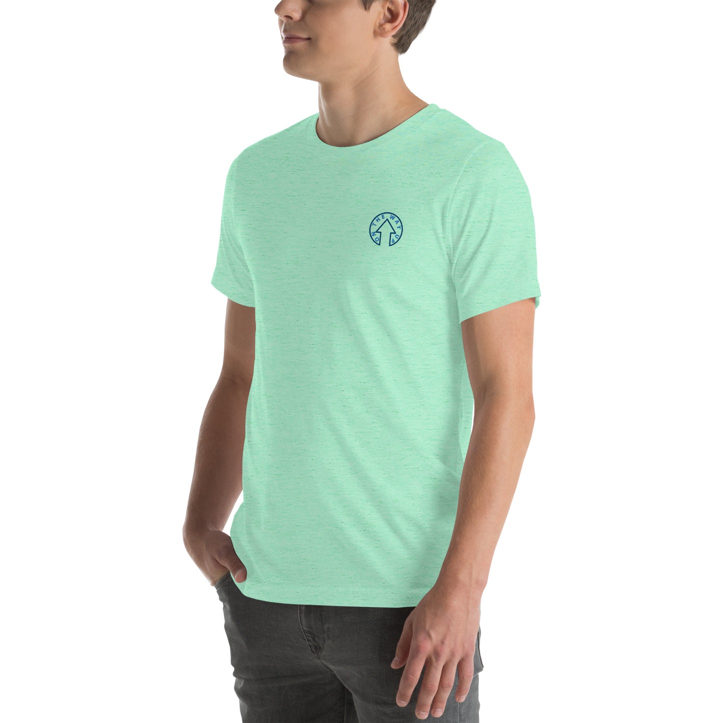 Young man in a On The Way Up Apparel BE BOLD - On The Way Up Embroidered Logo T-shirt in mint green, with a small emblem on the left chest, standing against a white background, looking to his left.