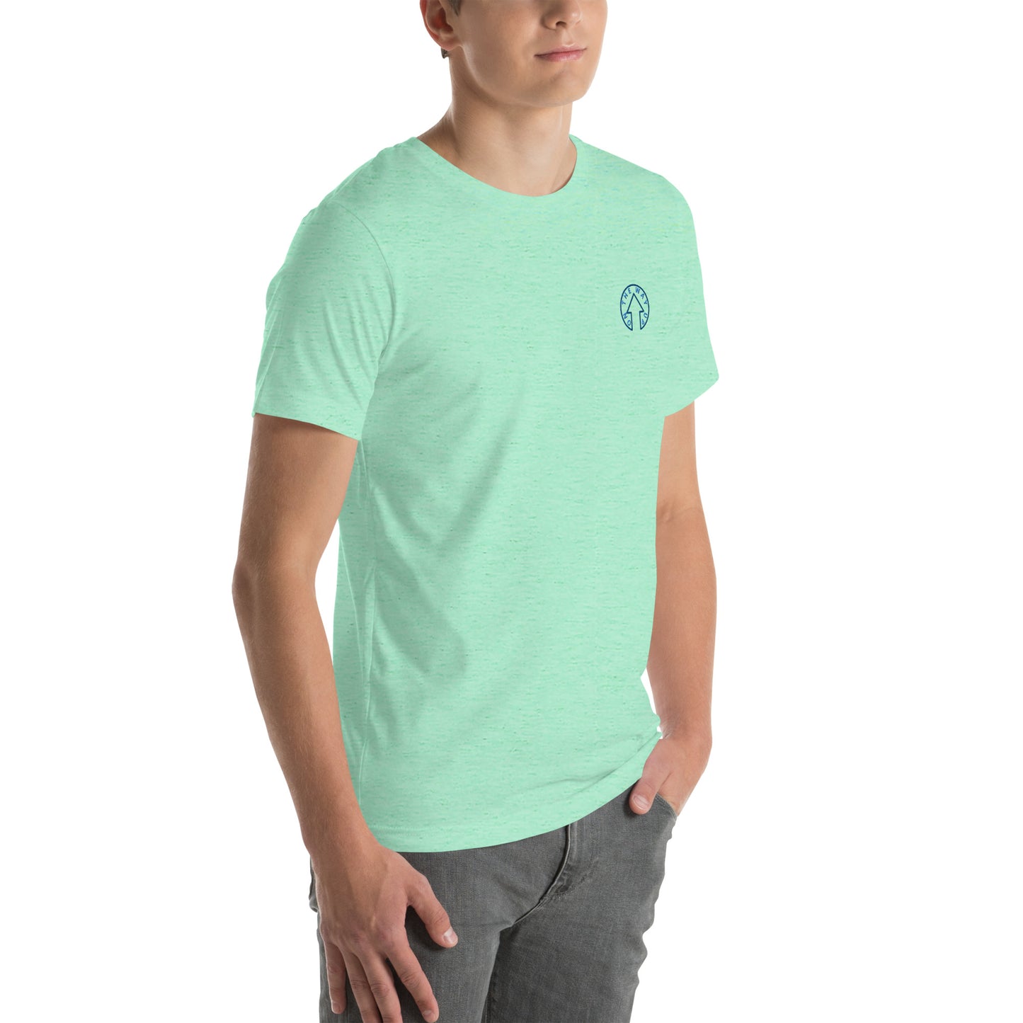 A young man wearing an On The Way Up Apparel BE BOLD - On The Way Up Embroidered Logo T-shirt in mint, paired with grey jeans, standing against a white background.