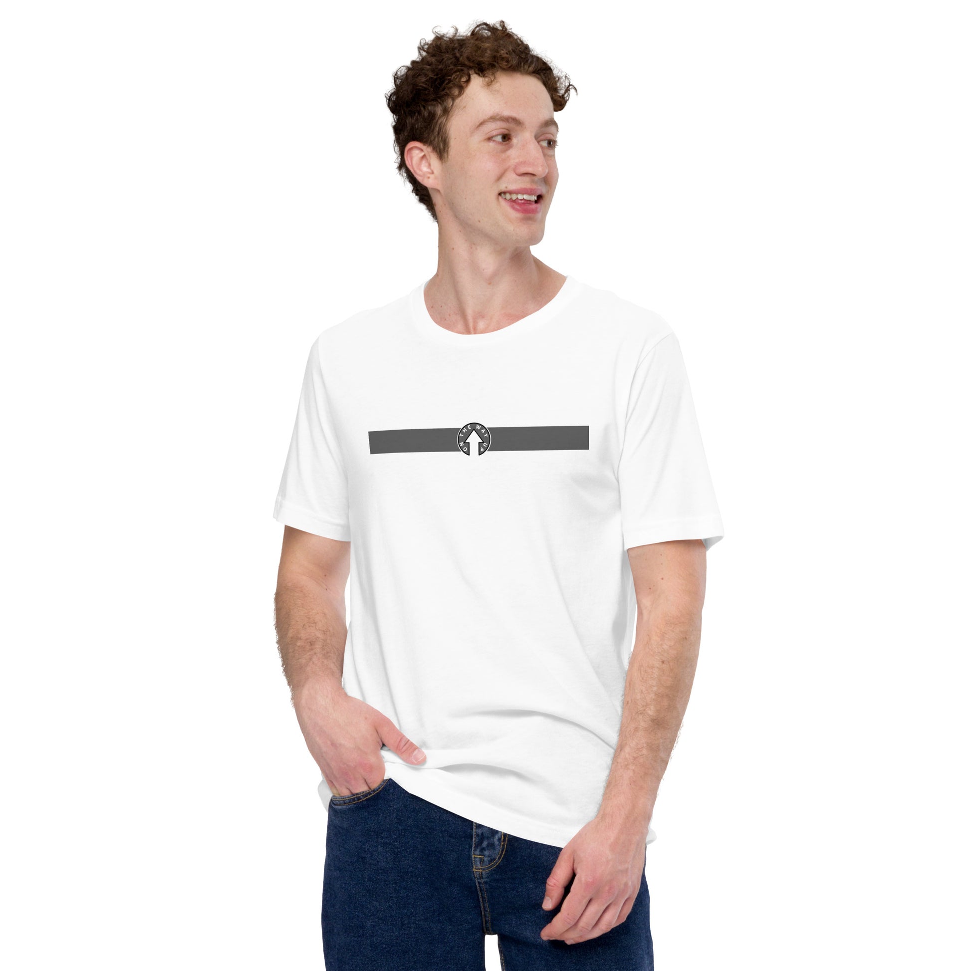 A young man with curly hair smiling and looking to his left, wearing an On The Way Up Apparel plain white t-shirt with a simple "Manchester" graphic design near the collar. He is casually holding the hem of his shirt, standing against a white background.