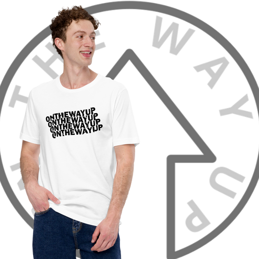 A young man with curly hair is posing with one hand in his jeans pocket, smiling and looking to the side. He is wearing a white "Circular Rotation Slogan Tee" from On The Way Up Apparel, made from super soft, combed and ring-spun cotton. The shirt features the repeated text "ON THE WAY UP" in black font. In the background, the same phrase and an upward arrow inside a circle are displayed.