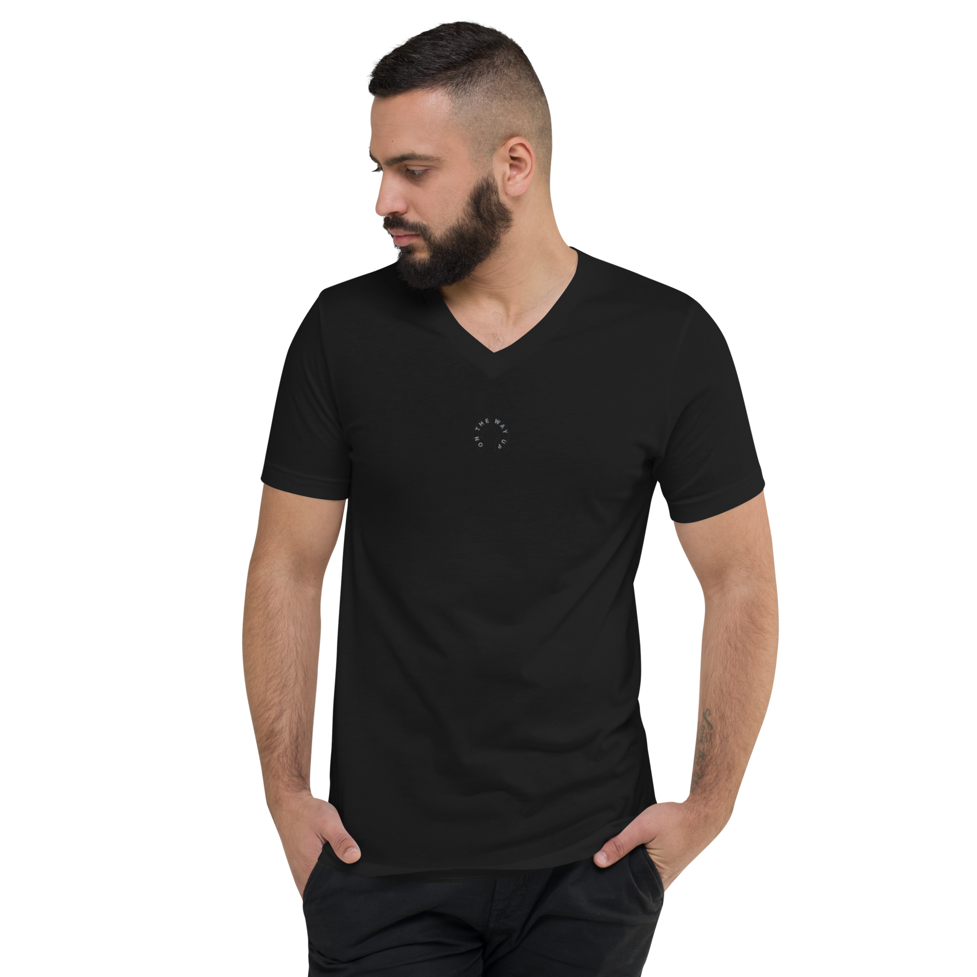 A man with a beard wearing an On The Way Up Apparel Signature Short Sleeve V-Neck T-Shirt in black, looking to his left, on a black background.